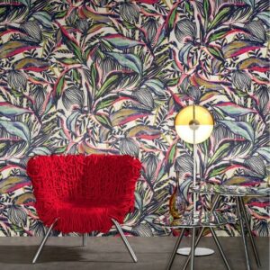 Interieur met kleurrijk Arte-behang uit de Flor Imaginaria-collectie, een rode designstoel en een moderne tafellamp.