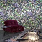 Kleurrijk interieur met Arte Florimaginaria-behang, een paarse loungestoel, glazen bijzettafel en abstract vloerkleed.