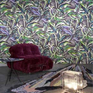 Kleurrijk interieur met Arte Florimaginaria-behang, een paarse loungestoel, glazen bijzettafel en abstract vloerkleed.