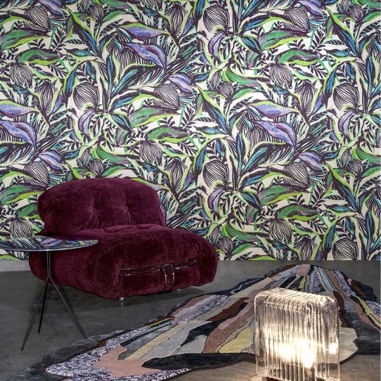 Kleurrijk interieur met Arte Florimaginaria-behang, een paarse loungestoel, glazen bijzettafel en abstract vloerkleed.