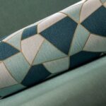 Rol Arte-behang Insolence Blast met geometrisch patroon in blauw-, wit- en goudtinten op een groene achtergrond.