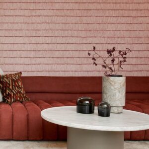 Moderne zithoek met rood Arte-behang Insolence Shiver, een ronde marmeren tafel en decoratieve vaas.