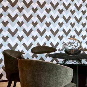 Moderne eetkamer met Arte-behang Insolence Vanity in een geometrisch patroon en een glazen tafel met decoratief object.