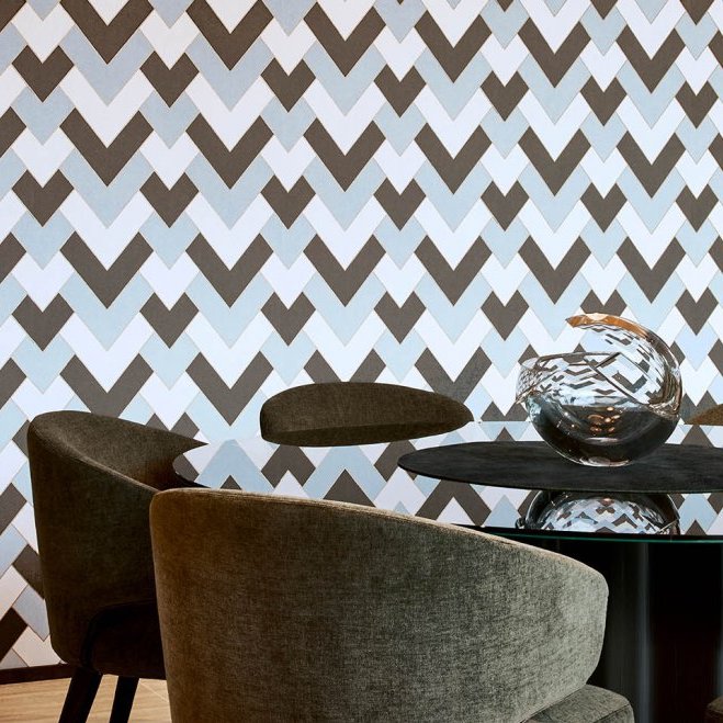 Moderne eetkamer met Arte-behang Insolence Vanity in een geometrisch patroon en een glazen tafel met decoratief object.
