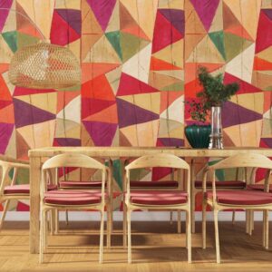 Eetkamer met houten meubelen en kleurrijk geometrisch Arte-behang JV800 Tierra Savana 6633 op de achtergrond.