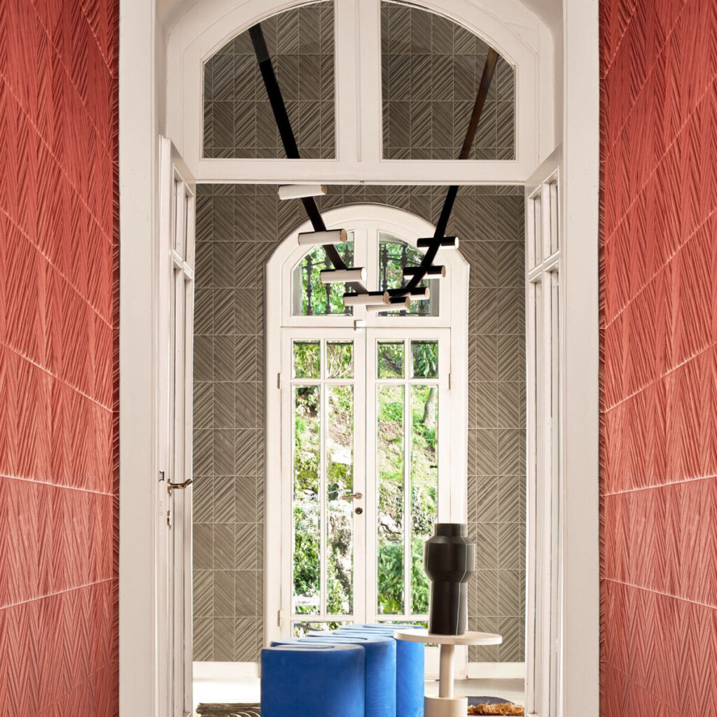 Stijlvolle gang met Arte behang uit de Kanso Iki 72510 collectie in rood en grijs, moderne verlichting en blauwe zitpoefs.