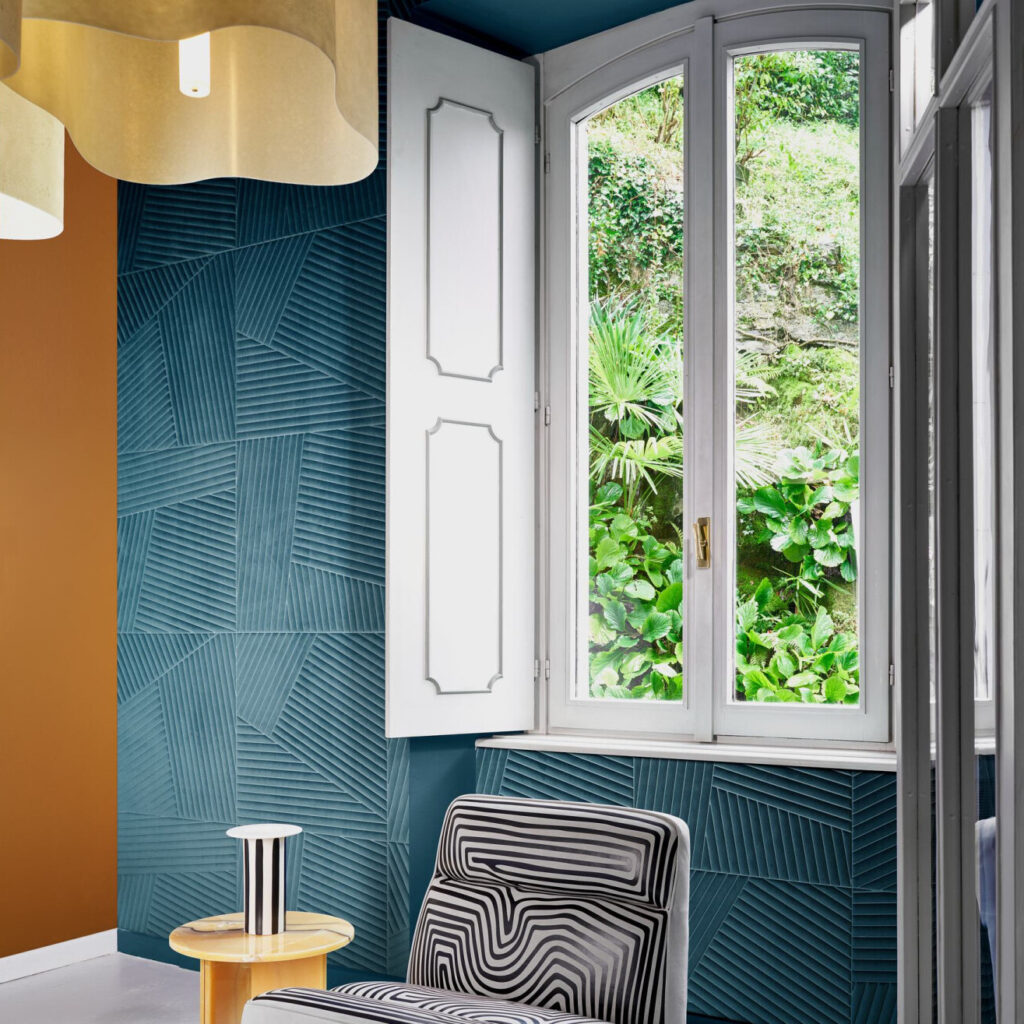 Interieur met Arte-behang Kanso Shibumi 72530 in blauwgroen reliëfpatroon, naast een raam met uitzicht op weelderig groen.