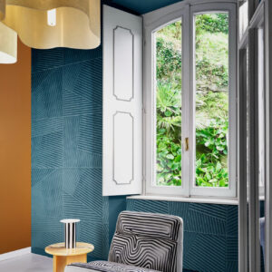 Interieur met Arte-behang Kanso Shibumi 72530 in blauwgroen reliëfpatroon, naast een raam met uitzicht op weelderig groen.