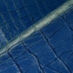 Close-up van blauw Arte Kharga 74026 leerbehang met een krokodillenhuidstructuur.