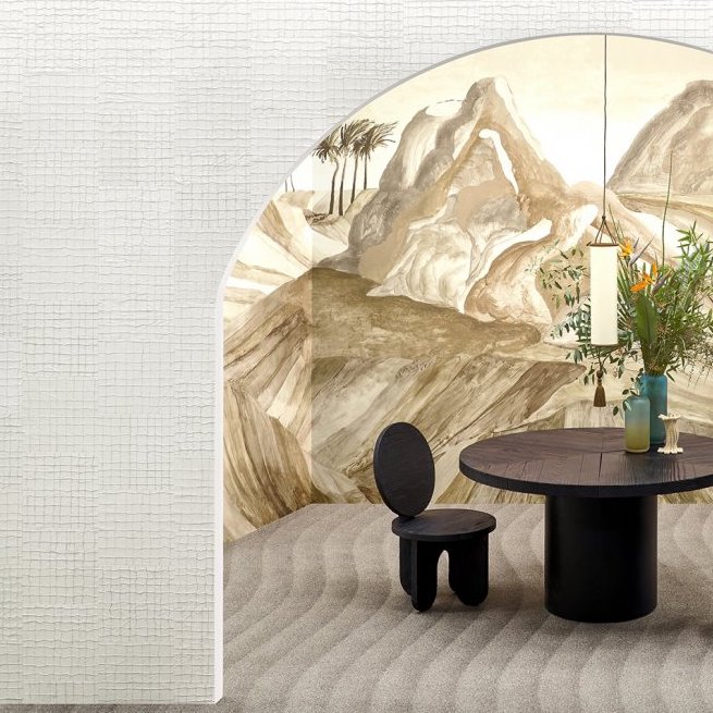 Moderne zithoek met een zwart ronde tafel en stoel voor een muur met Arte Kharga 74027 leerbehang met bergachtig landschap.