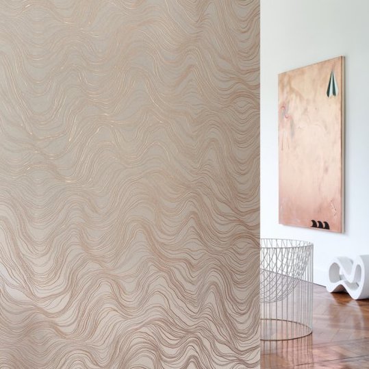 Sfeervolle kamer met Arte behang Kharga Bayuda 74041 in de kleur sunrise copper met een golvend, glinsterend patroon.