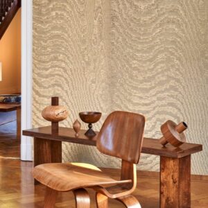 Hedendaags interieur met Arte-behang Kharga Moiré in bright gold, houten designmeubels en decoratieve objecten.