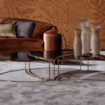 Luxe interieur met Arte Kharga Moiré 15012A sunset orange behang, fluwelen bank en moderne glazen salontafels.