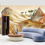 Moderne woonkamer met een afgeronde bank en houten salontafel, tegen een kleurrijk woestijnlandschap op het Arte Kharga Zerzura 74060 panorama behang in warme zandtinten.