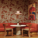 Sfeervolle zithoek met rood Arte-behang Lanai Kailua 81500, ronde eettafel en houten stoelen.