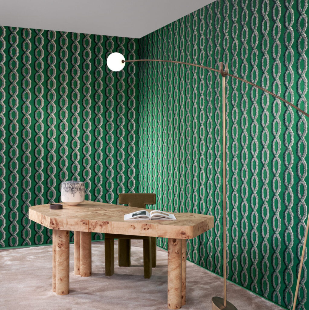 Moderne kamer met groen Arte-behang LeCouturier Franges 58520 en een houten bureau met boek en decoratie.