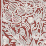 Gedetailleerd wit botanisch en granaatappel-patroon op een terracotta achtergrond van het Arte-behang Le Couturier La Perle.