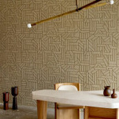 Modern interieur met Arte-behang La Dérive 58501 in geometrisch patroon achter een minimalistische eettafel en houten stoelen.