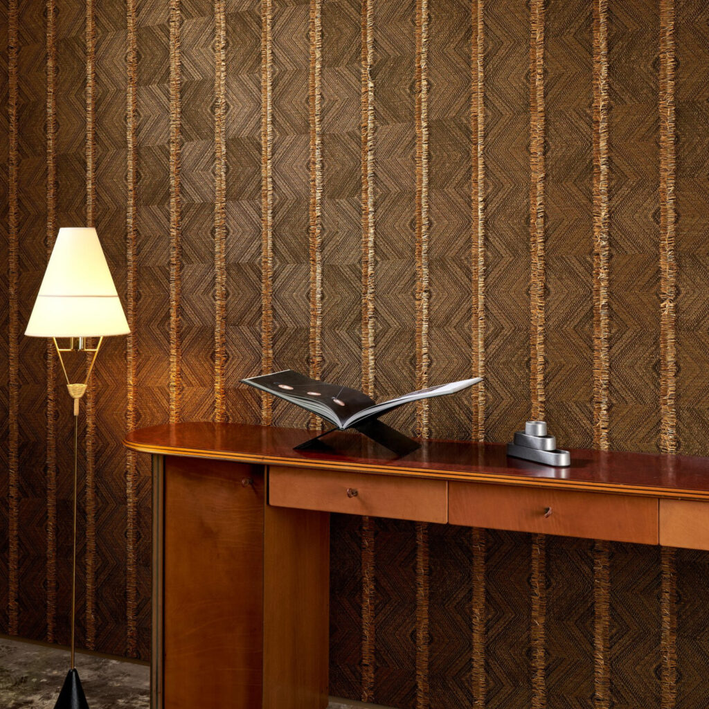 Sfeervolle interieurhoek met Arte-behang Majesto 58510, houten console, designlamp en open tijdschrift.