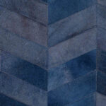 Blauw Arte-behang uit de Les Cuirs Montage-collectie met een patroon van chevronvormige lederen vlakken.
