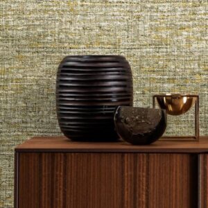 Donker keramisch decor, gouden schaal en halve steenobject op houten kast met Arte-behang Lino Aspero op de achtergrond.