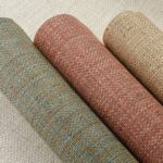Drie rollen geweven Arte Nongo behang uit de Gitane collectie in natuurlijke tinten.