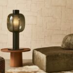 Moderne woonkamer met Arte-behang Oblong, een glazen tafellamp en een fluwelen chaise longue.