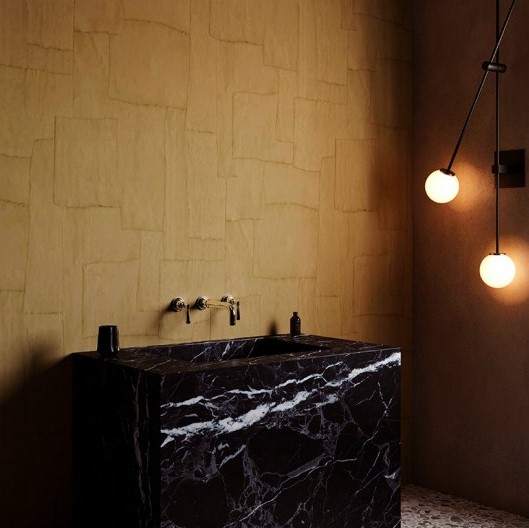 Luxe badkamer met Arte-behang Oblong, een zwart marmeren wastafel en sfeervolle hanglampen.