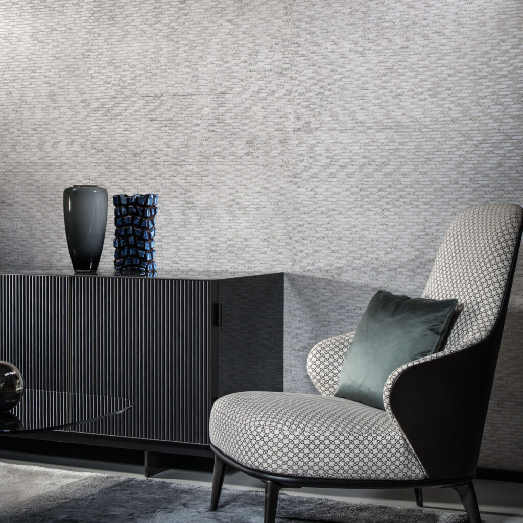 Moderne woonkamer met Arte behang Papyrus 48550, een design fauteuil en een zwarte kast met decoratieve vazen.