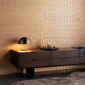 Moderne woonkamer met Arte Papyrus-behang in goudtinten, een donkere houten kast en een stijlvolle messing tafellamp.