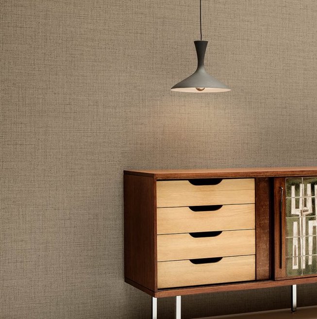 Houten dressoir en hanglamp tegen een muur met Arte behang Puro 27000 in linnenstructuur.