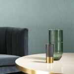 Moderne interieursetting met Arte Temper behang, een fluwelen stoel, ronde tafel en decoratieve vazen.