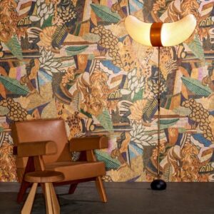 Bruin Arte Terra Tropicana behang met tropisch patroon, gecombineerd met een leren stoel en een decoratieve staande lamp.
