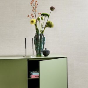 Groene kast met een vaas met bloemen, kandelaars en een potje tegen een Arte Textura Marsh 31501A behang.