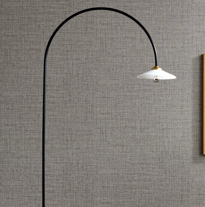 Booglamp met witte kap voor een muur bekleed met Arte behang Textura Puro 27009A.