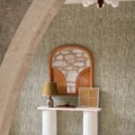 Interieur met Arte-behang Tresse 48051 Sepia uit de Les Forêts-collectie, een nisdecoratie en stijlvolle accessoires op een witte zuilconsole.
