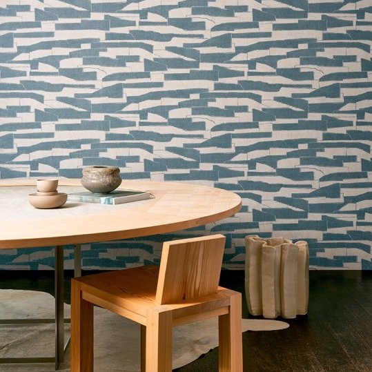 Moderne eetkamer met Arte Essentials Costura Gabarit 57562 blauw behang en minimalistisch houten meubilair.