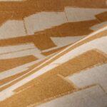 Close-up van het Arte behang Essentials Costura Gabarit 57564 met een geel geometrisch patroon en textiele structuur.