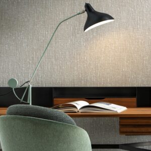 Moderne werkplek met Arte Les Tricots Boucle behang, een designlamp, mintgroene stoel en open tijdschrift op een houten bureau.