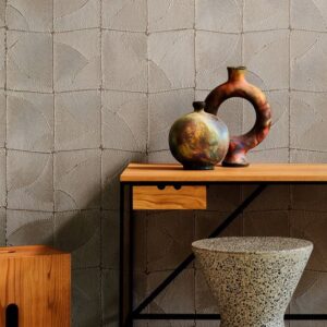Moderne interieursetting met Arte Atlas 64534 behang, een houten tafel met kunstzinnige vazen en een terrazzo kruk.