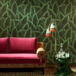 Rode fluwelen bank tegen Arte-behang Bird of Paradise met groen tropisch bladerpatroon.
