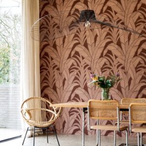 Moderne eetkamer met Arte behang Botanic 64502 in warme tinten en natuurlijke rotanmeubels.