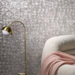 Luxe interieur met Arte Camber 33731 behang in schelpmotief, zachte fauteuil en gouden vloerlamp.