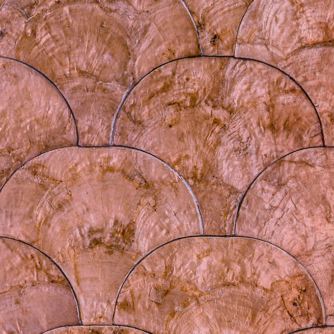 Close-up van Arte behang Camber 33733 met een patroon van geschakelde halve cirkels in een koperachtige tint.