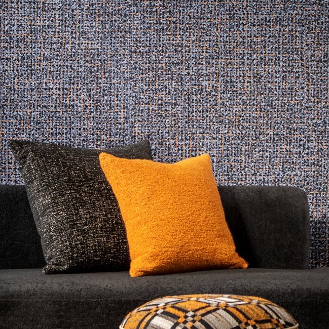 Gezellige zithoek met Arte Cashmere 73063 behang en sierkussens in zwart en oranje.