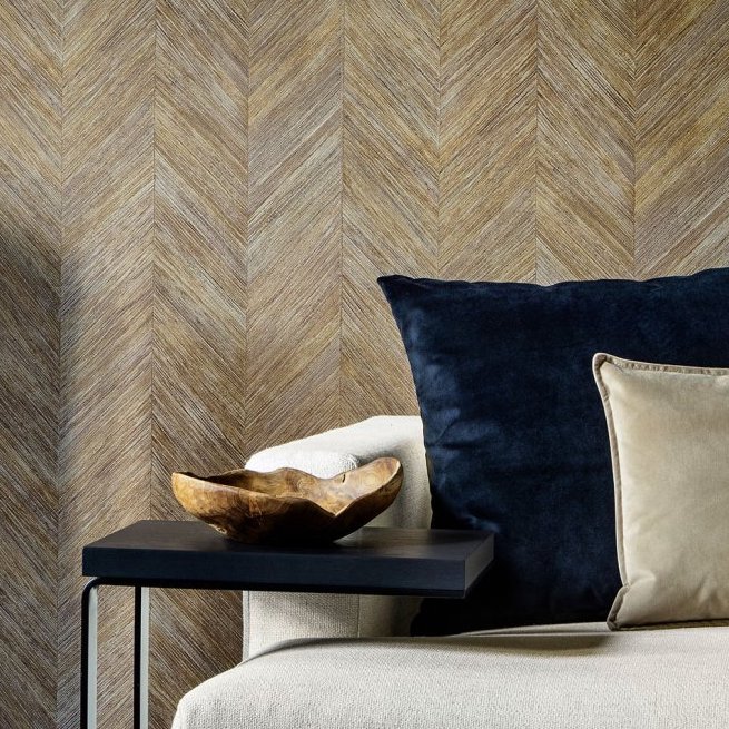 Luxe interieur met Arte behang Corteza 34202 in visgraatpatroon, een crèmekleurige fauteuil en donkere kussens.