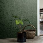 Groen Arte Emaille-behang met een reliëfstructuur, met een plant in een zwarte pot en een rieten mand op de vloer.