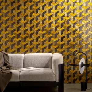 Moderne woonkamer met Arte Helix behang in goud en bruin geometrisch patroon achter een beige bank.