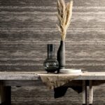 Stijlvolle opstelling met Arte Lustro behang, een stenen tafel en decoratieve vazen met siergras.