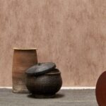 Rustiek interieur met Arte behang Manchas in aardetinten en decoratieve manden op een grijze vloer.